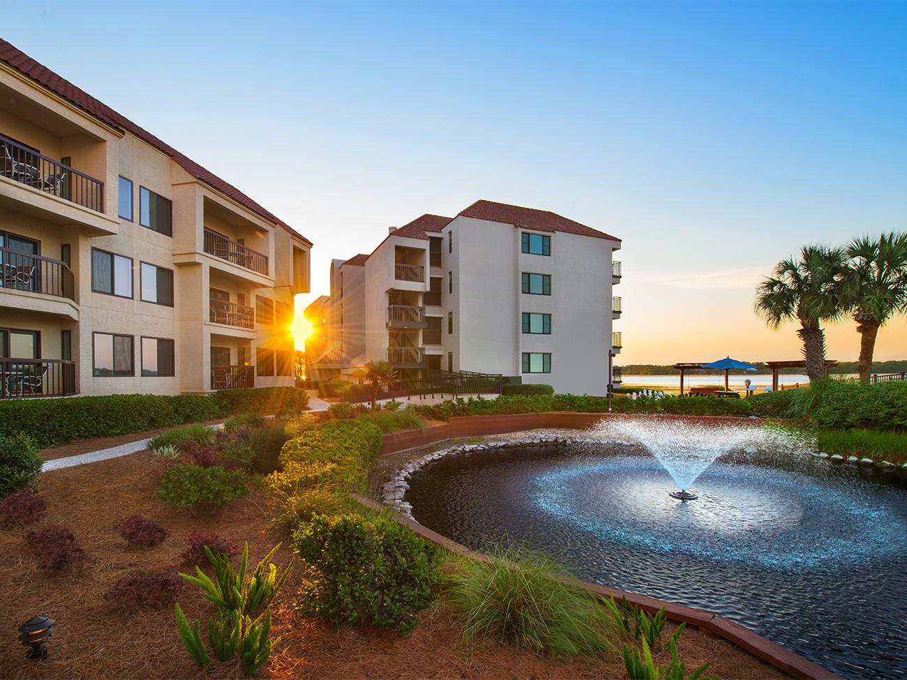 Exterior and grounds of Marriott's Sunset Pointe resort timeshare with pond fountain in foreground